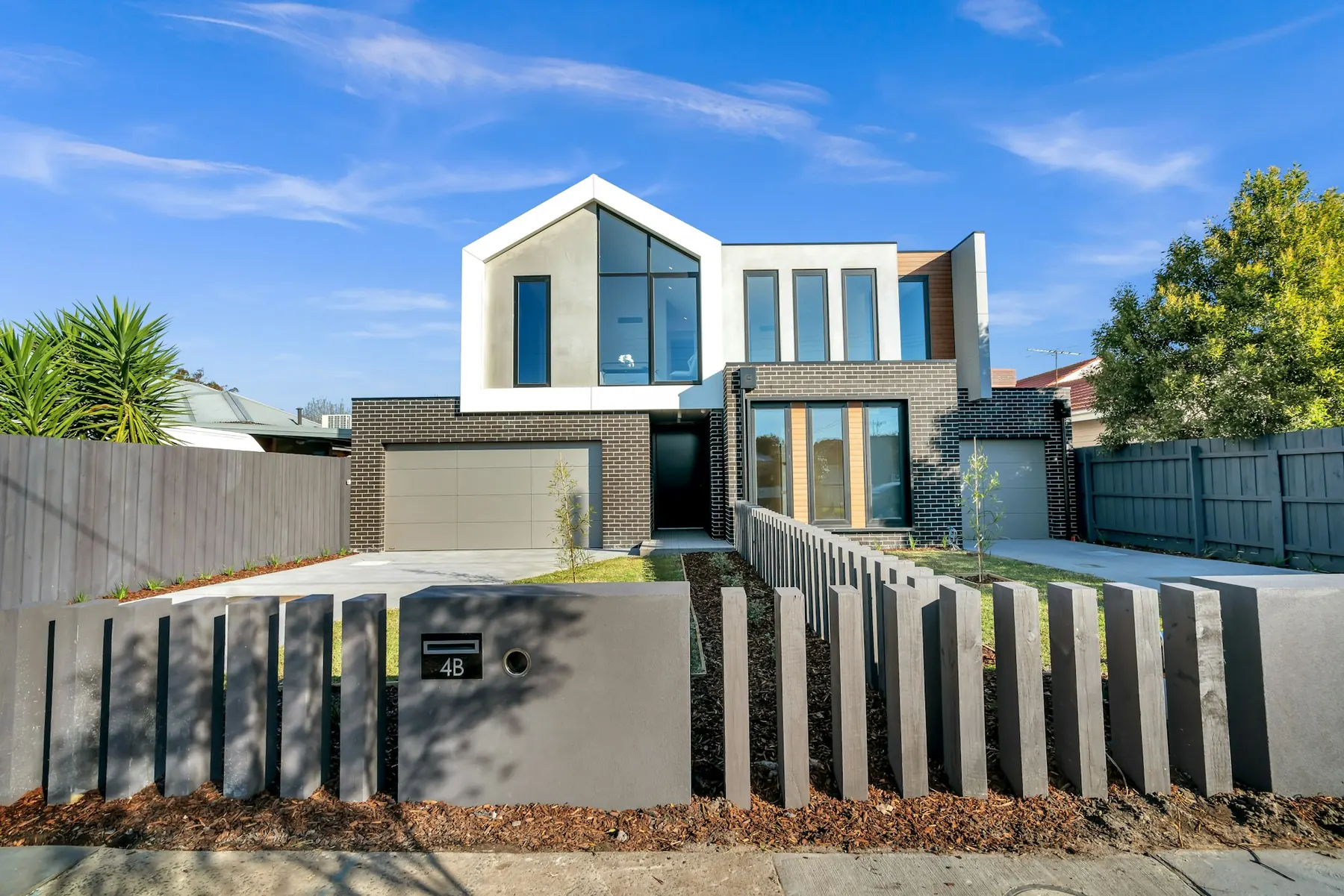 Modern white and grey house with slatted boundary wall