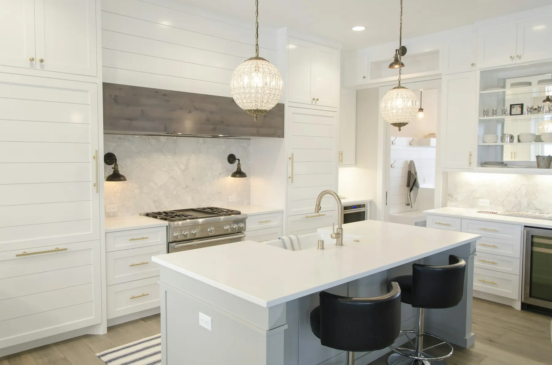 White kitchen with marble island and pendant lights