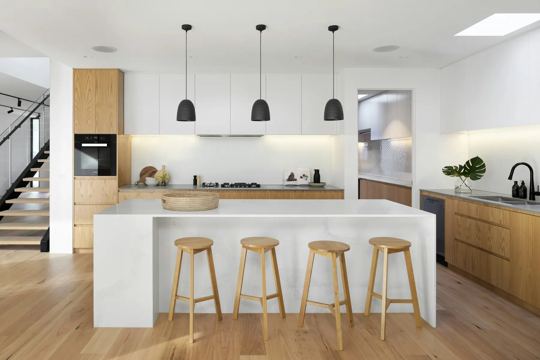 White kitchen with timber island and bar stools