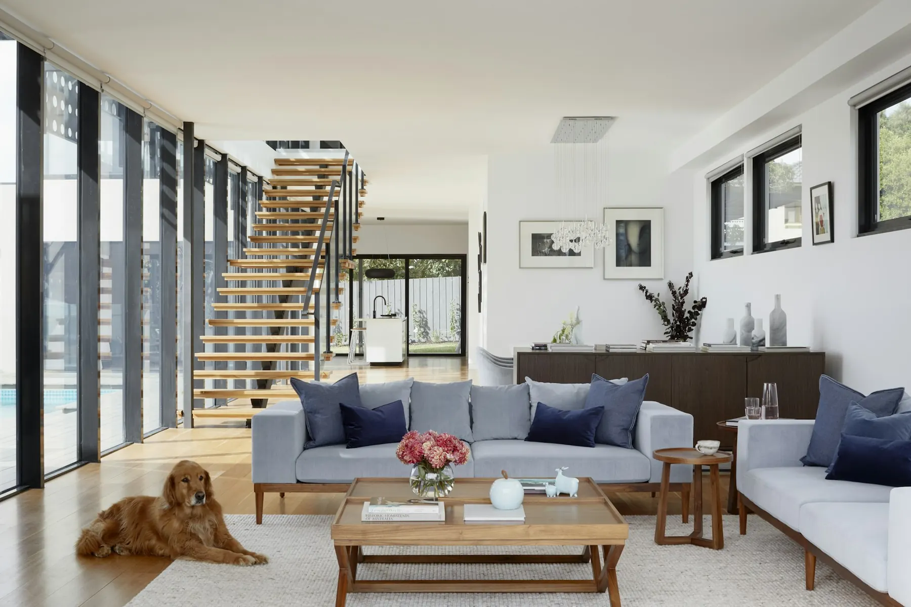 Open living room with large sofas and floor-to-ceiling windows