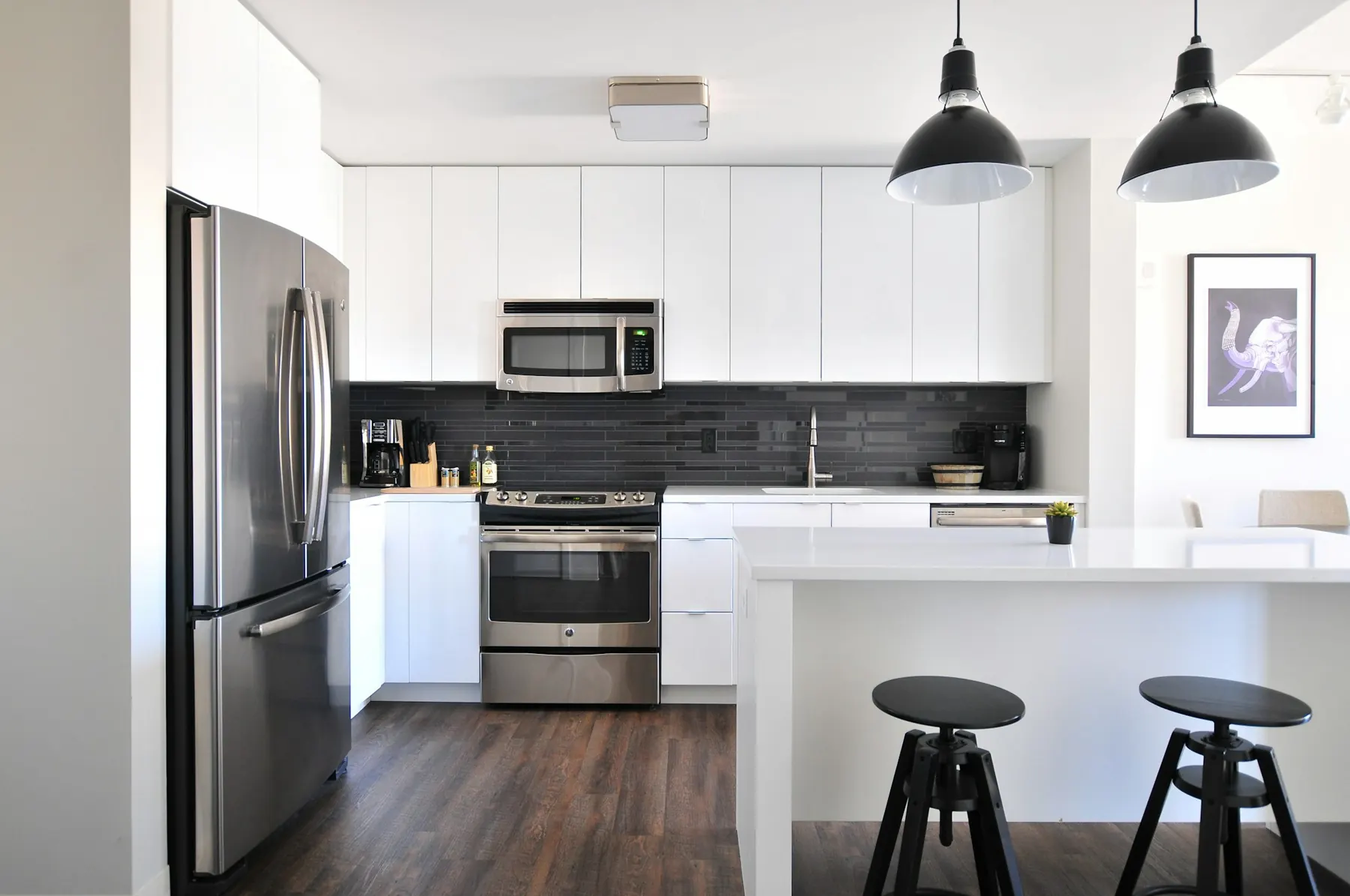 Compact white kitchen with bar stools
